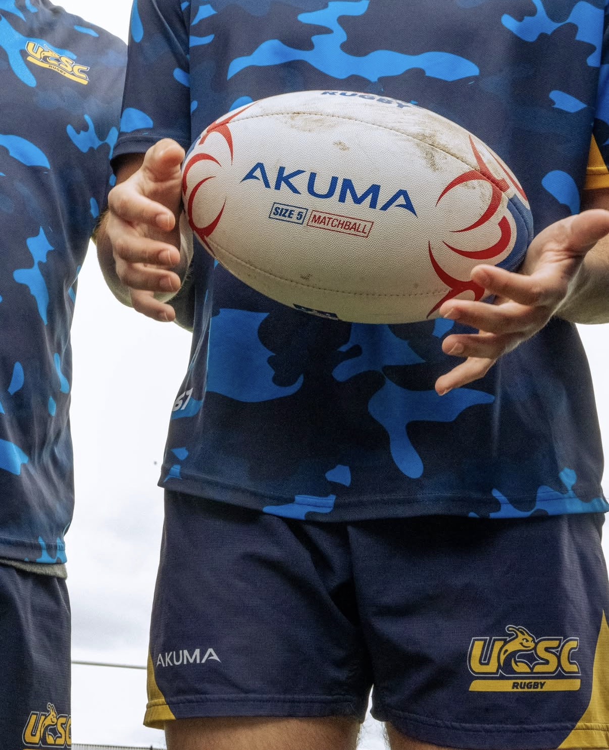 A Slug Rugby player holding a match ball